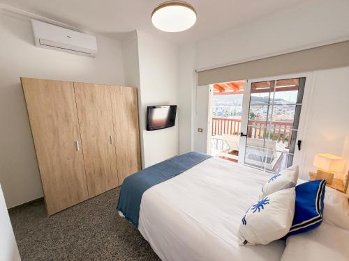 a bedroom with a large white bed and a window at Sea Breeze Arguineguin in Mogán