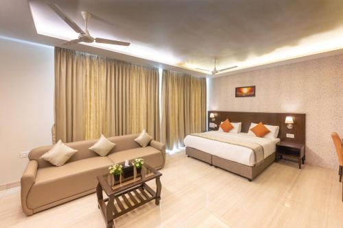 a hotel room with a bed and a couch at Fortune Plaza Hotel in Udupi