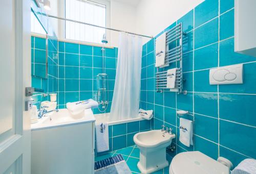 a blue tiled bathroom with a toilet and a sink at Relais Miramar in Termini