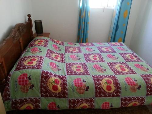 ein Bett mit einer rosa und grünen Decke darauf in der Unterkunft Kammal Villa in Flic-en-Flac