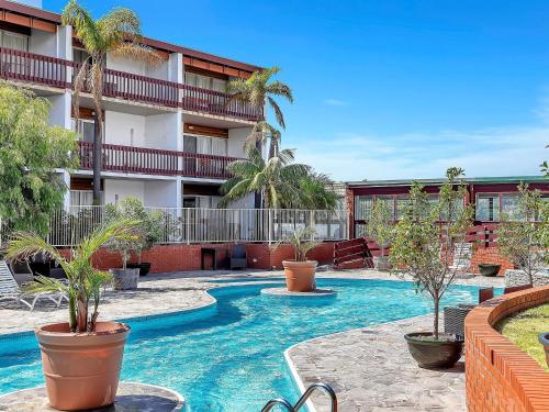a swimming pool with palm trees in a hotel at BreakFree Wirrina Cove in Wirrina Cove