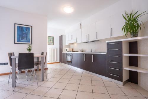 a kitchen with a table and a dining room at Castel View Apartment - Gardaslowemotion in Tenno