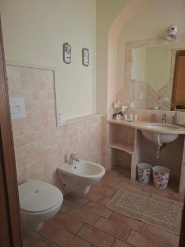 a bathroom with a toilet and a sink at B&B La Pavoncella in San Teodoro