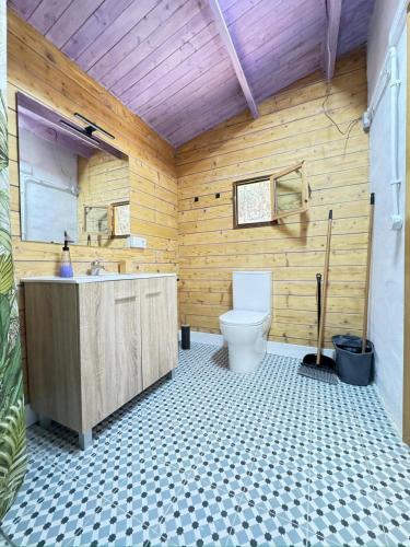 a bathroom with a toilet and a wooden wall at Can Cospito in Osor