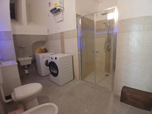 a bathroom with a shower and a washing machine at Tursi Relais Virtus in Tursi