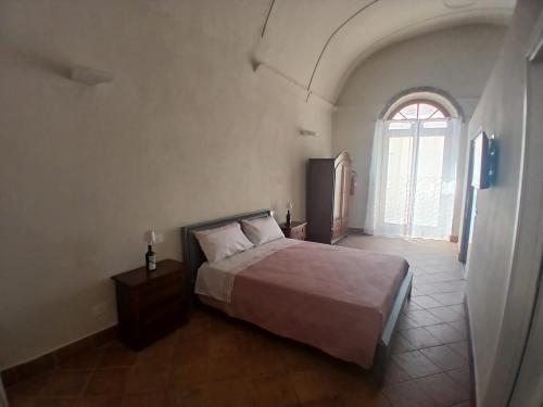 a bedroom with a bed and a large window at Tursi Relais Virtus in Tursi