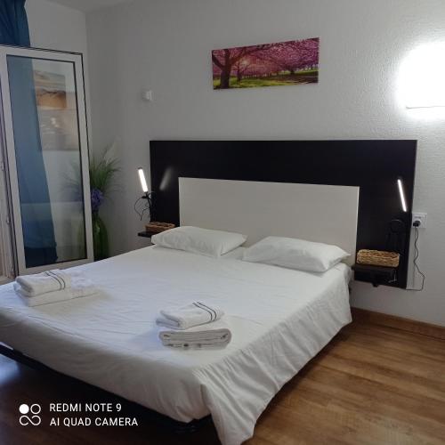 a bedroom with a large bed with two towels on it at résidence la citadelle in Saint-Florent