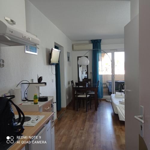 a kitchen and a living room with a table at résidence la citadelle in Saint-Florent
