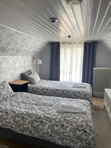 two beds in a hotel room with blue walls and windows at Huset på hörnet in Hammenhög
