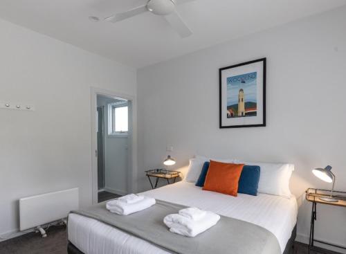 a bedroom with a white bed with towels on it at The Dickins in Woodend