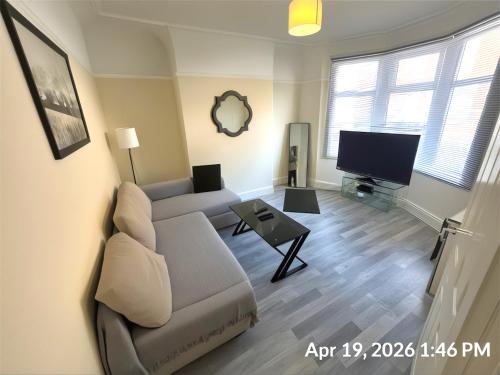 a living room with a couch and a tv at Stirling Steet in Wallasey