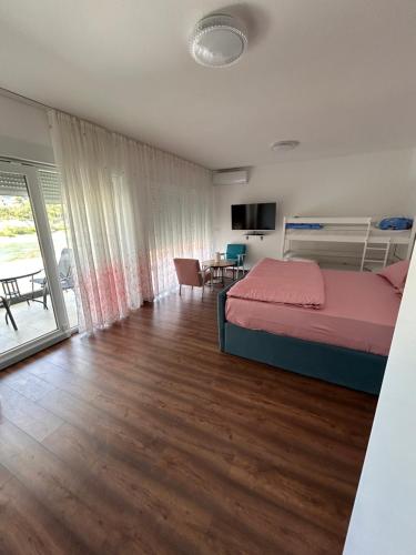 a bedroom with a bed and a living room at Apartmani SEEBLICK in Konjic