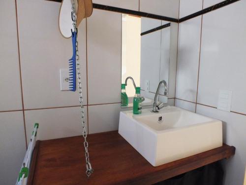 een badkamer met een witte wastafel en een spiegel bij Sol de Geriba condominio com casas in Búzios