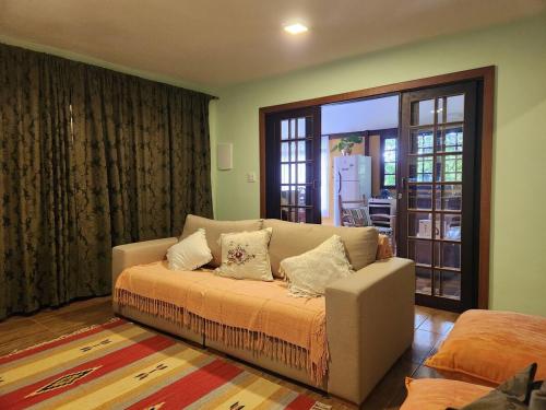 a living room with a couch with pillows on it at Casa Limoeiro in Petrópolis