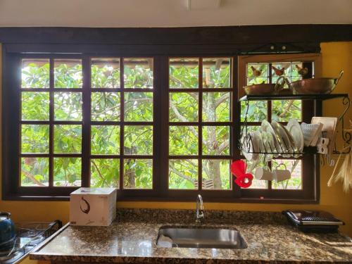 a kitchen counter with a sink and a window at Casa Limoeiro in Petrópolis