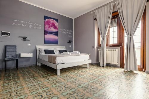 a bedroom with a bed and a wall with a painting at Malù House in Fiumicino