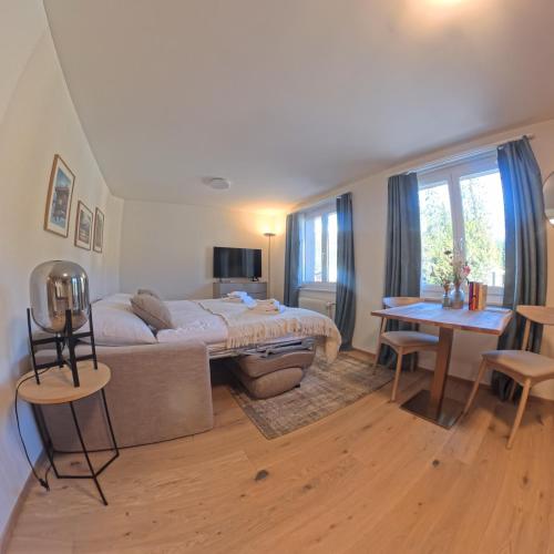 a bedroom with a bed and a desk and a table at Design-Studio nahe der Piste Lenzerheide in Lenzerheide