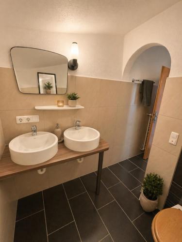 a bathroom with two sinks and a mirror at Gästezimmer Lercher in Sankt Veit im Pongau