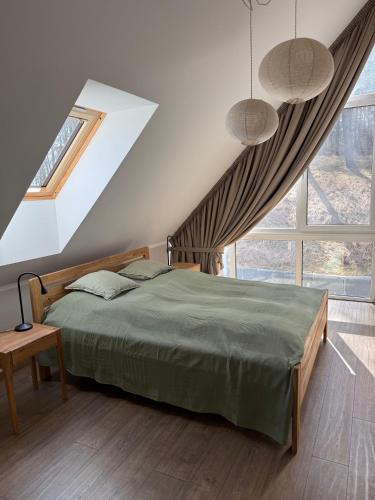 a bedroom with a bed and a large window at Aura Kaszub Lake&Forest in Łączyno