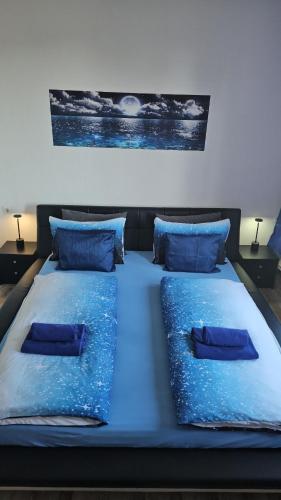 ein Bett mit blauen Laken und Kissen in einem Zimmer in der Unterkunft Harzspaß in Braunlage