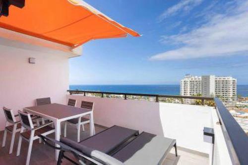 a balcony with a table and chairs and the ocean at Eden Rentals Olympia Sunny Seaviews in Playa de las Americas