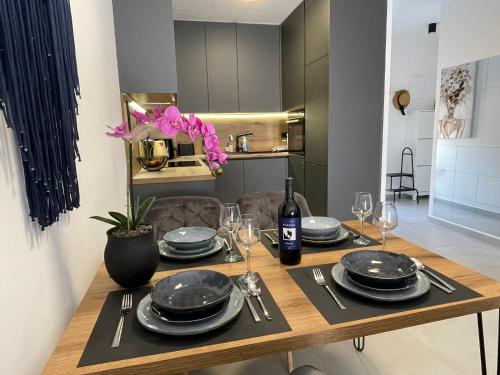 a dining room table with plates and wine glasses at Slatine Residence Apartament No 1 in Slatine