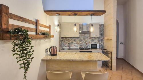 a kitchen with a counter with chairs and a island at Galati House in Melendugno