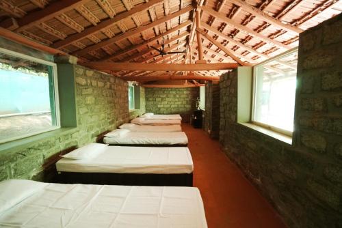 a row of beds in a room with windows at Annmees Freedom Land in Bangalore