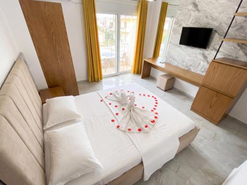 a bedroom with a white bed with a cake on it at Hotel Four Islands in Ksamil