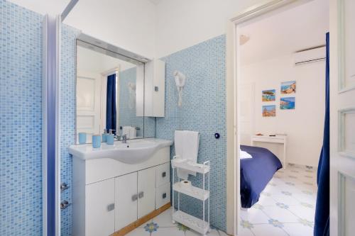 a bathroom with a sink and a blue tiled wall at Authentic Oasis - Villa La Solara in Anacapri