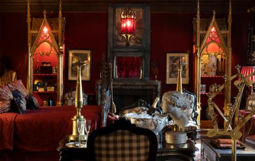 a red bedroom with a bed and a fireplace at The Witchery in Edinburgh