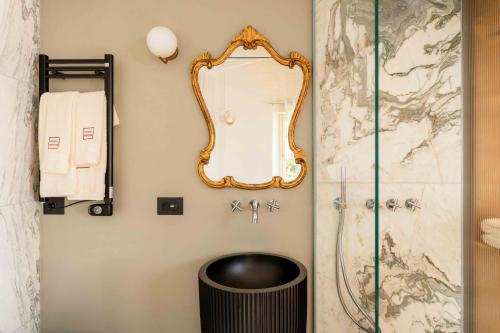 a bathroom with a mirror and a trash can at Dimora Moncher in Montignoso