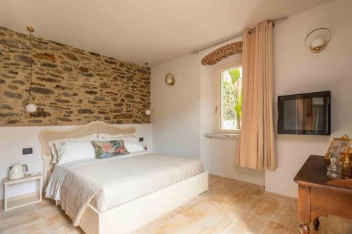 a bedroom with a bed and a stone wall at Dimora Moncher in Montignoso