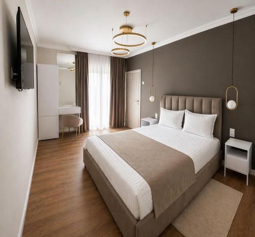 a large bedroom with a large bed and a desk at Pensiunea Brici Junior in Cluj-Napoca