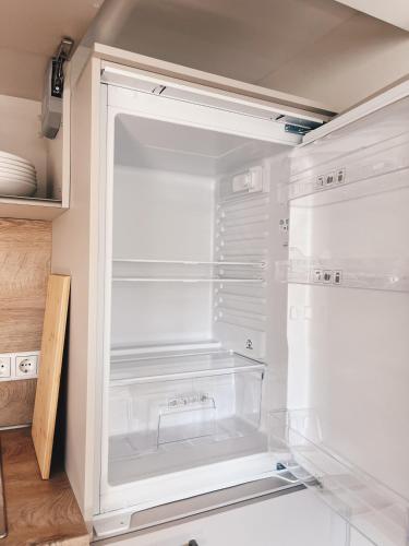an empty refrigerator with its door open in a kitchen at Alter Bahnhof Sichtigvor in Warstein