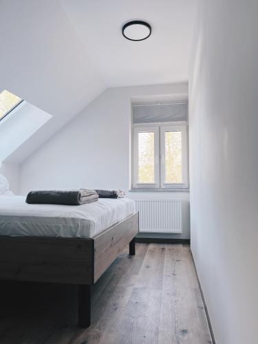 a white bedroom with a bed and a window at Alter Bahnhof Sichtigvor in Warstein