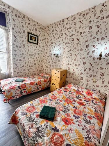 a bedroom with two beds and a comforter at Hotel Saint Francois Xavier in Lourdes