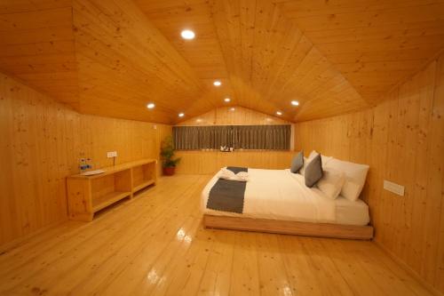 a bedroom with a bed and a wooden ceiling at DN Resort Dharamshala in McLeod Ganj