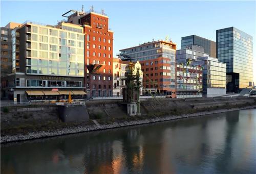 a city with tall buildings next to a river at Courtyard by Marriott Duesseldorf Hafen in Düsseldorf