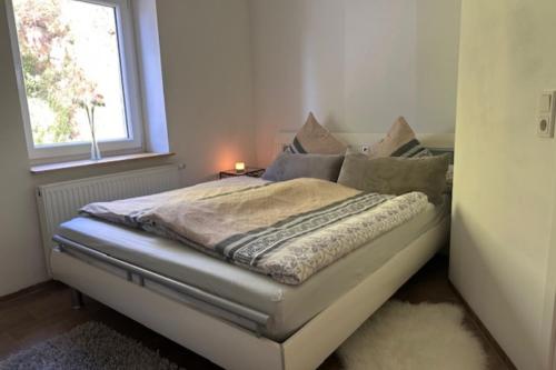 a bed in a small room with a window at NEU! Kleines Glück Illingen in Illingen