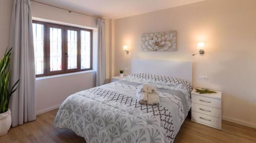 a white bedroom with a bed with a purse on it at Villa Infinity Torrox by Ruralidays in Torrox