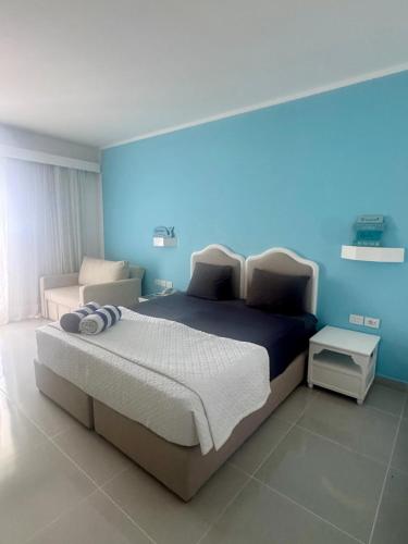 a bedroom with a large bed with a blue wall at MDS Coral Bay Pearl Sea View Resort in Sharm El Sheikh