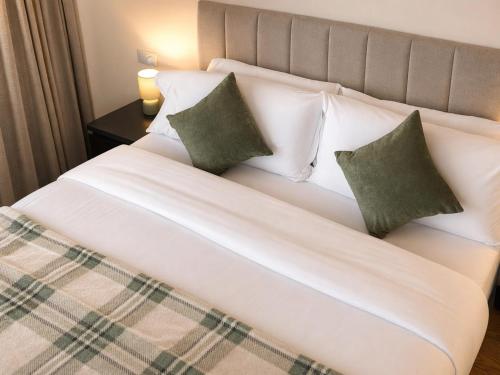 a large white bed with two pillows on it at Beyond Hotel & Apartments in Burnley