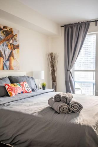 a bedroom with a bed with towels on it at Stylish 1BR plus Den Suite with Parking, Sleeps 4) in Toronto