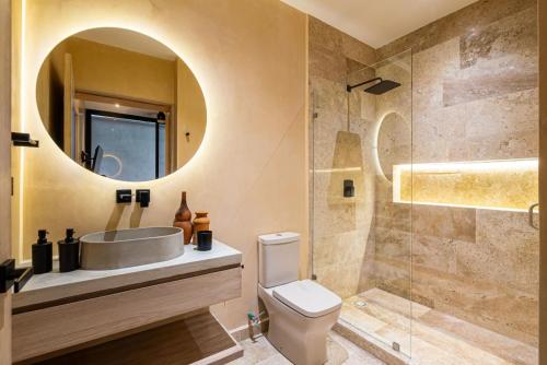 a bathroom with a sink and a toilet and a mirror at Luxury Beachfront 3BR Appartment in Tulum