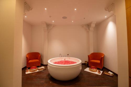 a room with a bath tub and two chairs at Taj Krishna in Hyderabad