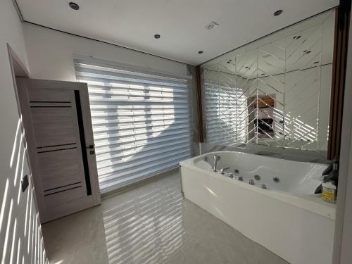 a bathroom with a tub and a window with a dog at Firepalace Gabala in Gabala