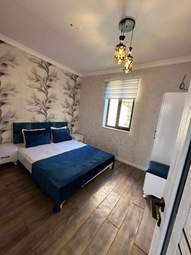 a bedroom with a blue bed and a window at Firepalace Gabala in Gabala