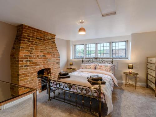 a bedroom with a bed with a brick fireplace at 3 Bed in Matlock oc-78591 in Cromford