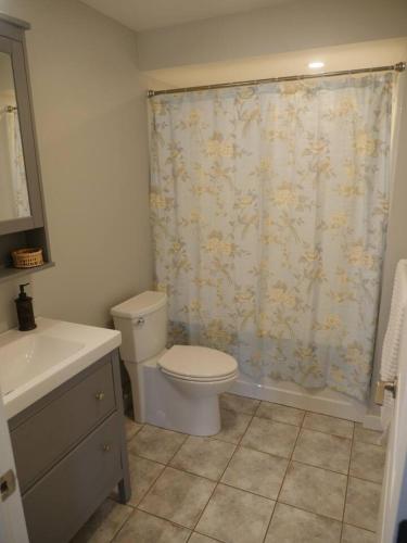 a bathroom with a toilet and a shower curtain at Howe Sound View in Bowen Island